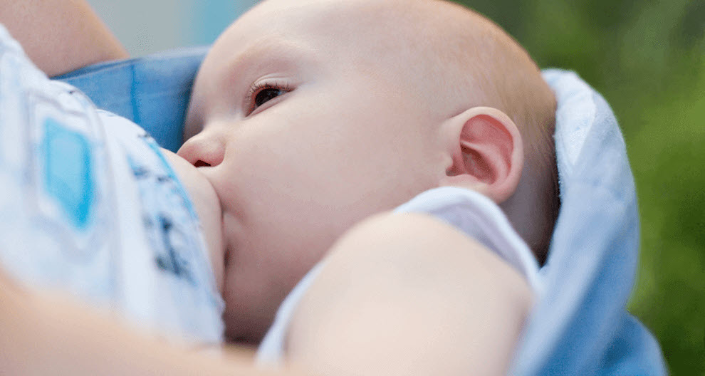 A close-up of a baby's face, partially obscured by a blue cloth, with a blurred background.